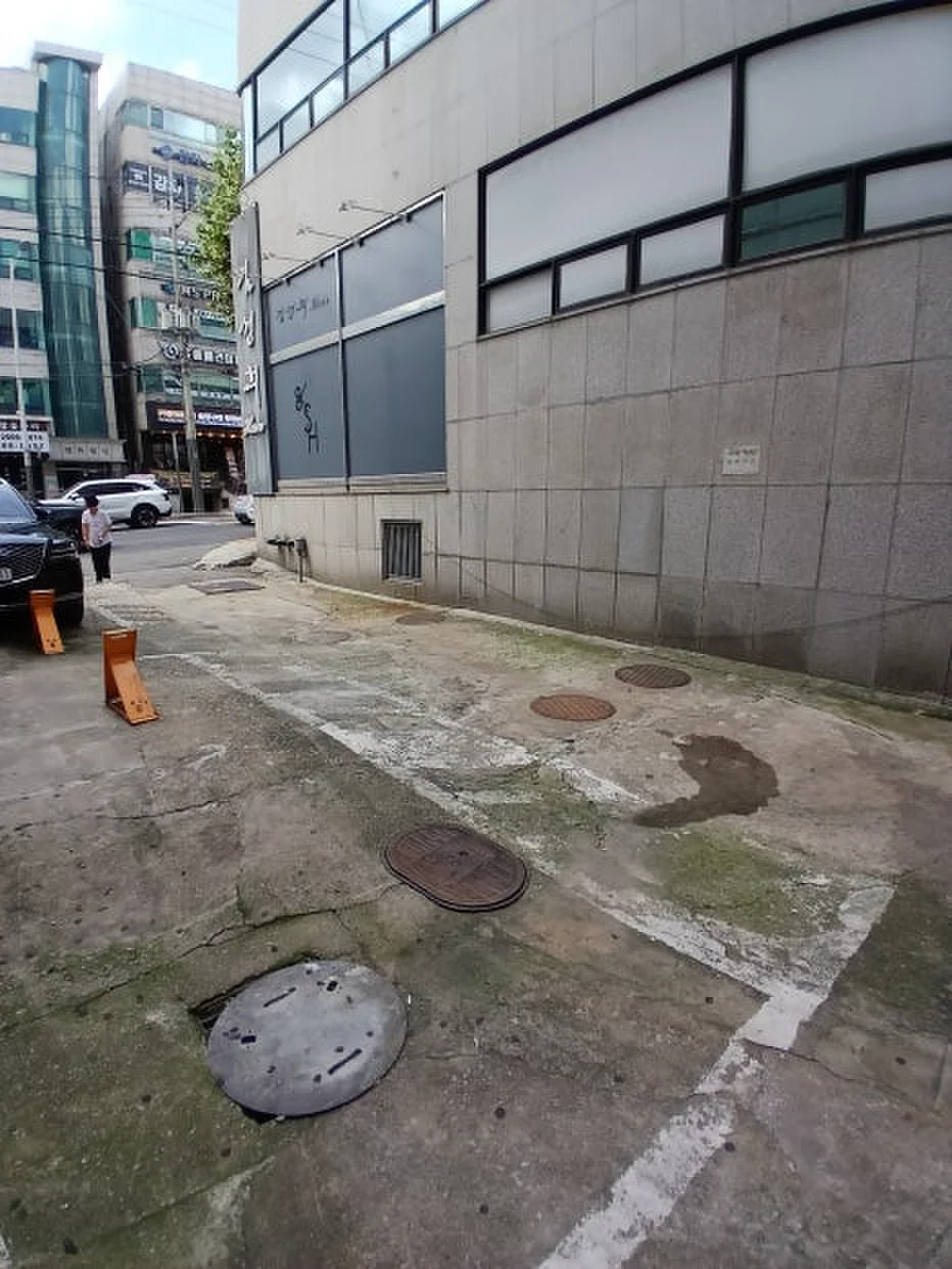 건물 모서리 맨홀이 있는 좁은 도로변 볼라드 설치 전 모습